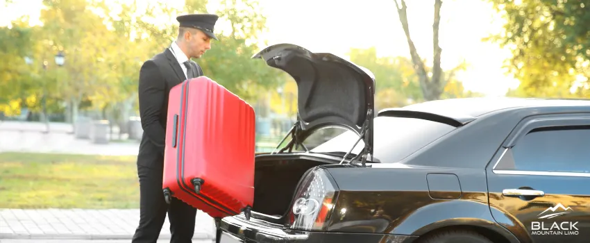 BML - A chauffeur putting passengers' suitcase in car trunk